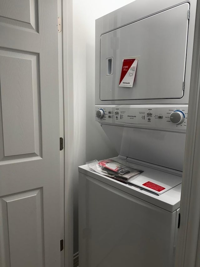 washroom featuring stacked washer / dryer and laundry area