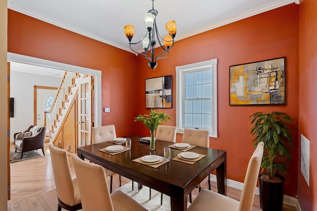 dining room featuring an inviting chandelier, baseboards, stairway, and ornamental molding