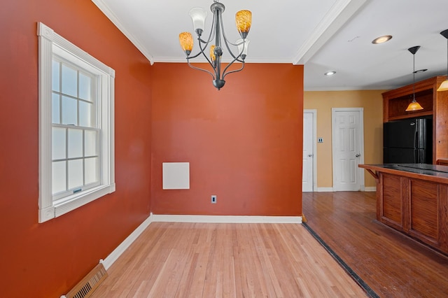 unfurnished dining area with ornamental molding, visible vents, and baseboards