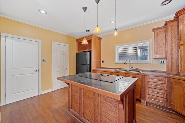 kitchen with a breakfast bar area, a sink, a center island, black appliances, and decorative light fixtures