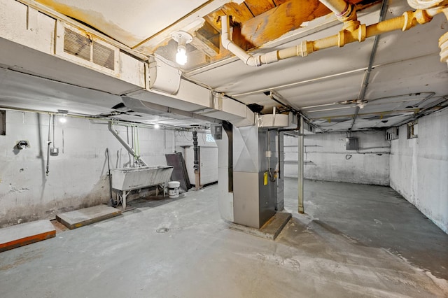 unfinished basement featuring electric panel, a sink, visible vents, and heating unit