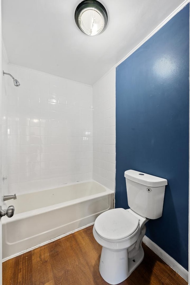 full bath with toilet, baseboards, shower / washtub combination, and wood finished floors