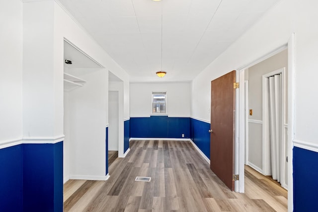 interior space with visible vents, wood finished floors, and wainscoting