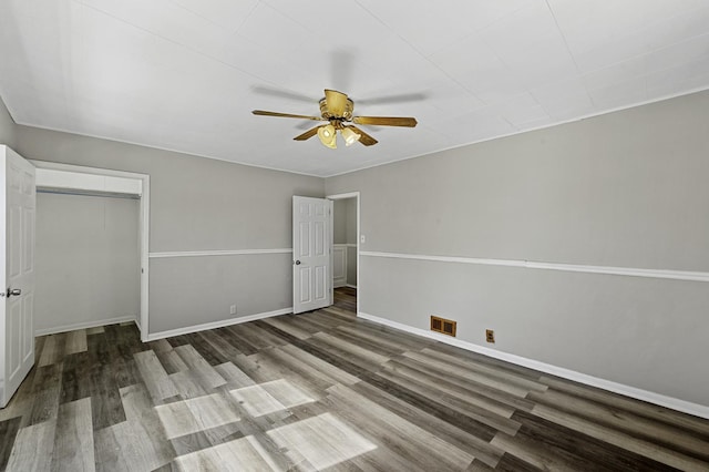 unfurnished bedroom featuring a closet, visible vents, ceiling fan, wood finished floors, and baseboards