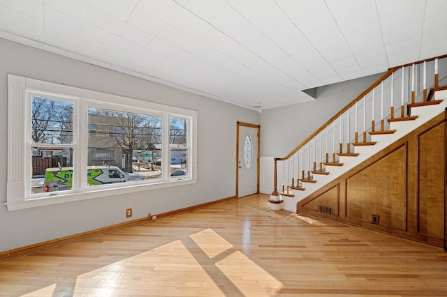 foyer with stairs, light wood finished floors, visible vents, and baseboards