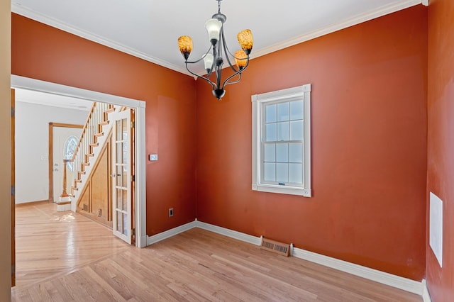 unfurnished dining area with a chandelier, light wood-style floors, crown molding, and baseboards