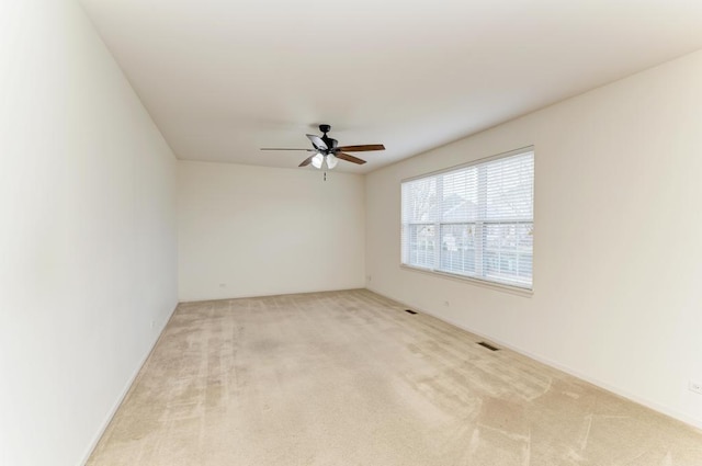 unfurnished room featuring light carpet and ceiling fan