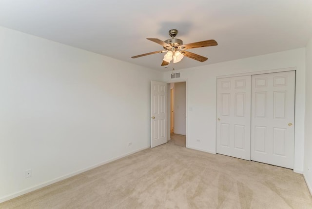 unfurnished bedroom with light carpet, ceiling fan, and a closet