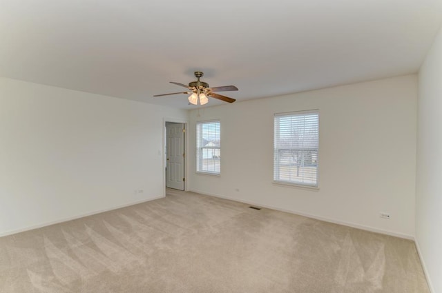 carpeted spare room featuring ceiling fan