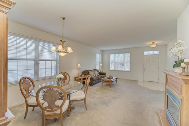 dining area with light carpet and a notable chandelier