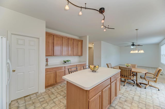 kitchen featuring a kitchen island, decorative light fixtures, white refrigerator, ceiling fan, and track lighting