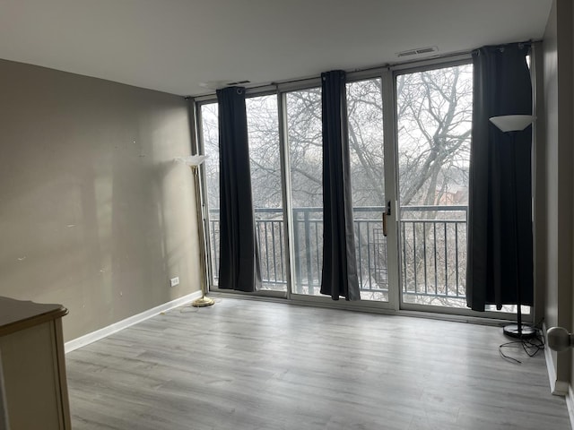 unfurnished room featuring light wood-type flooring and floor to ceiling windows