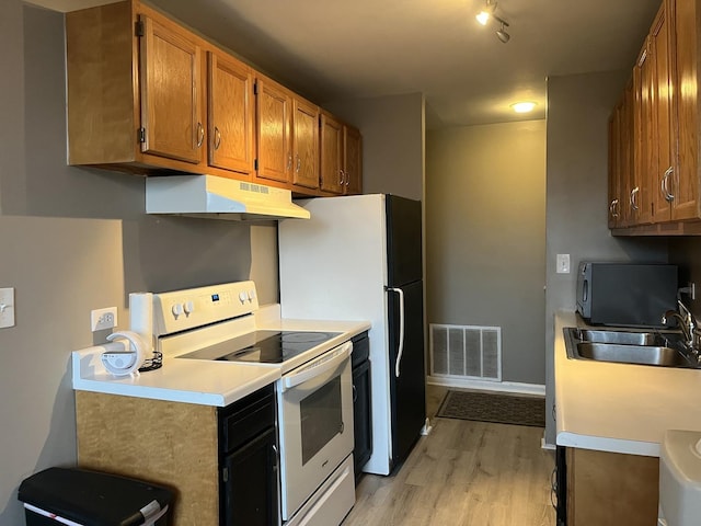 kitchen with sink, white electric range oven, and light hardwood / wood-style floors