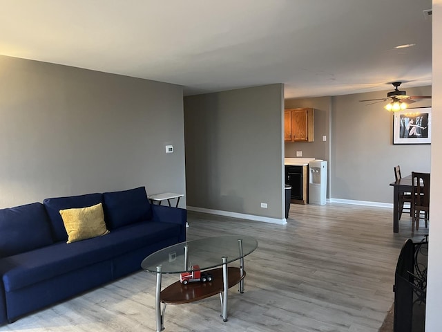 living room featuring light hardwood / wood-style flooring and ceiling fan