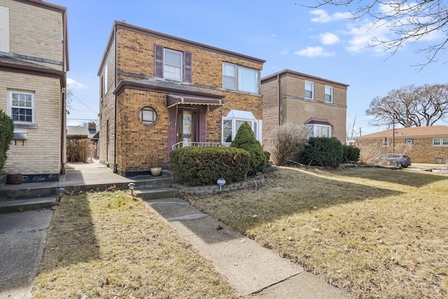 view of front of property featuring a front yard and brick siding