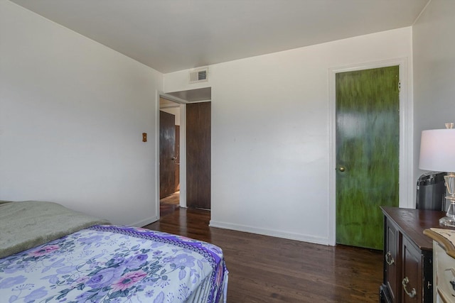 bedroom with visible vents, baseboards, and dark wood-style flooring