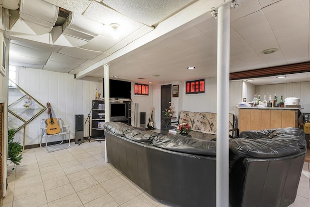 living area with light tile patterned floors and a drop ceiling