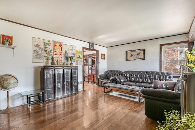 living area with ornamental molding and wood finished floors