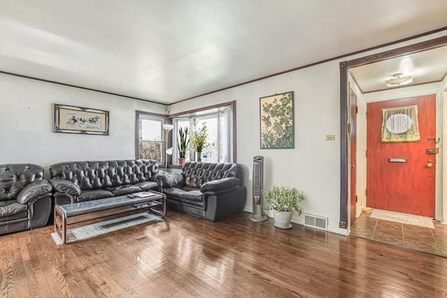 living area with visible vents, crown molding, and wood finished floors