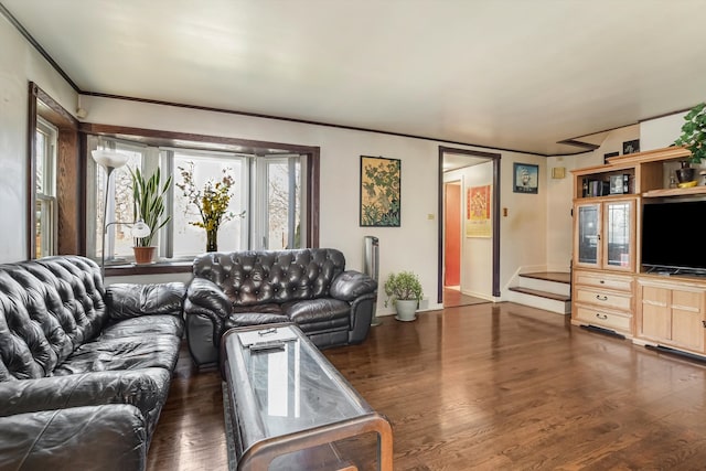 living area with crown molding, stairway, and wood finished floors