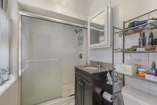 bathroom featuring vanity, toilet, and a stall shower