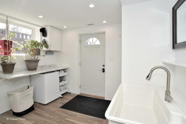 foyer entrance featuring light hardwood / wood-style flooring and sink