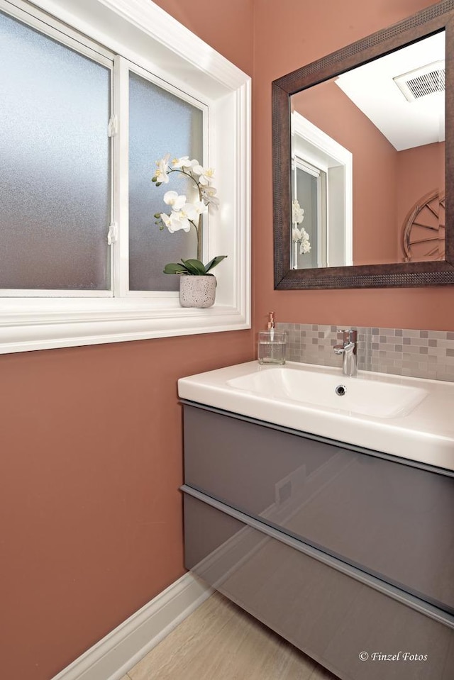 bathroom with tasteful backsplash and vanity