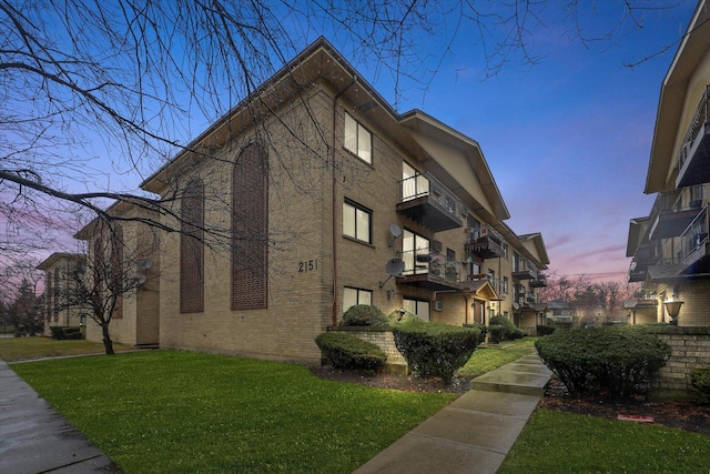 property exterior at dusk with a lawn