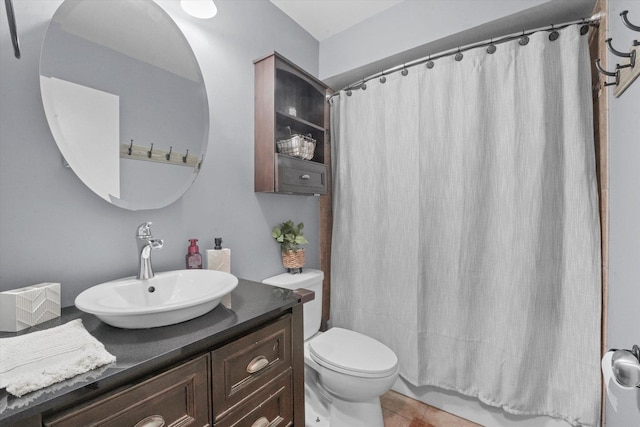 bathroom with toilet, vanity, and tile patterned flooring