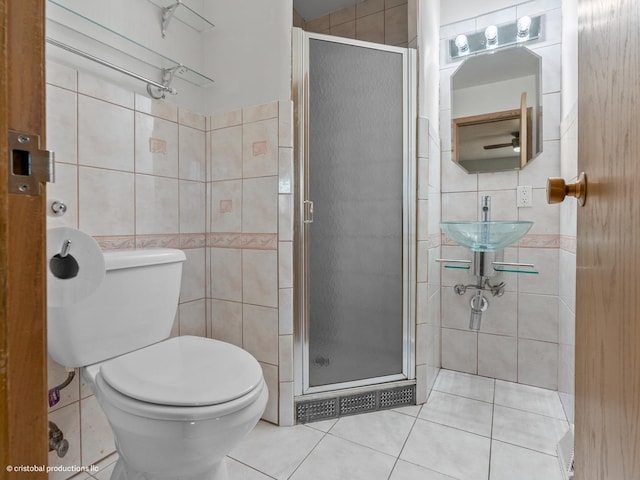 bathroom with tile patterned floors, a stall shower, tile walls, and a sink