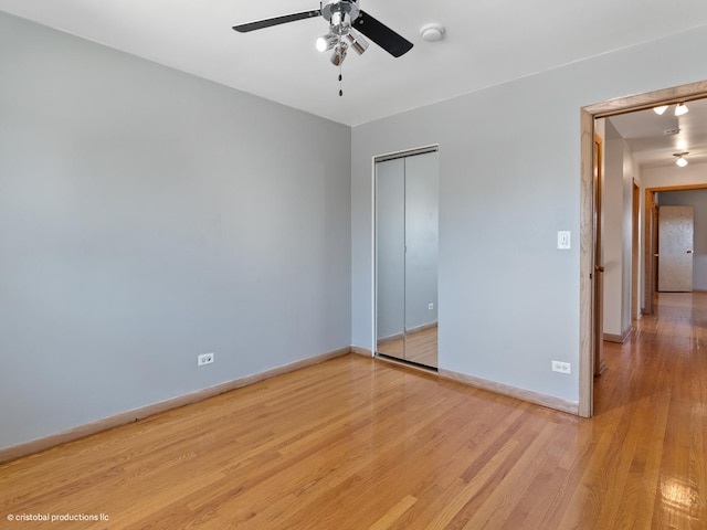 unfurnished bedroom with a closet, baseboards, ceiling fan, and light wood finished floors