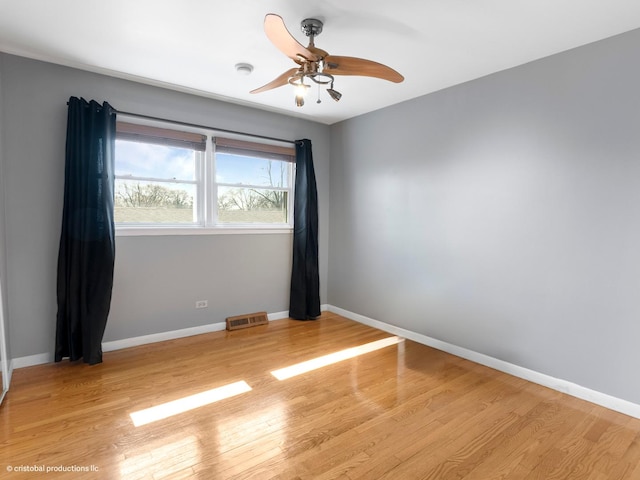 spare room featuring visible vents, light wood-style flooring, and baseboards