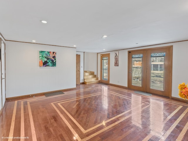 empty room featuring wood finished floors, baseboards, recessed lighting, stairs, and french doors