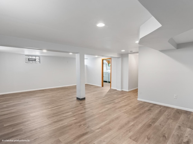 finished below grade area with light wood-style flooring, recessed lighting, and baseboards