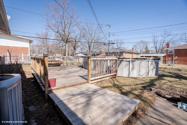 view of yard with an outdoor pool, central air condition unit, a deck, and fence