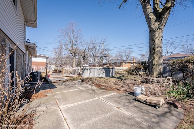 view of patio featuring central AC unit and fence