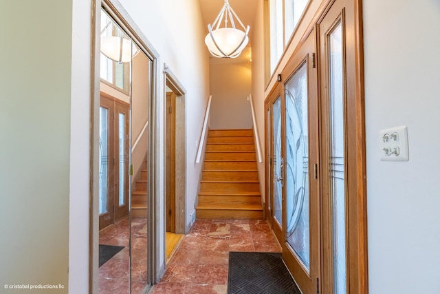 corridor with stairway and a high ceiling