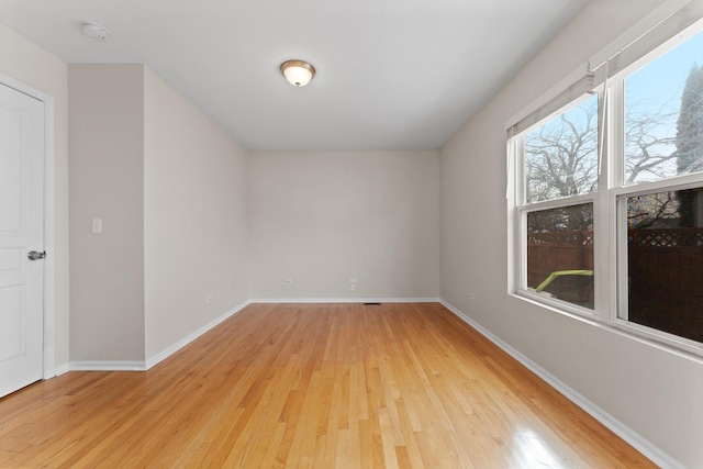 empty room with baseboards and light wood finished floors