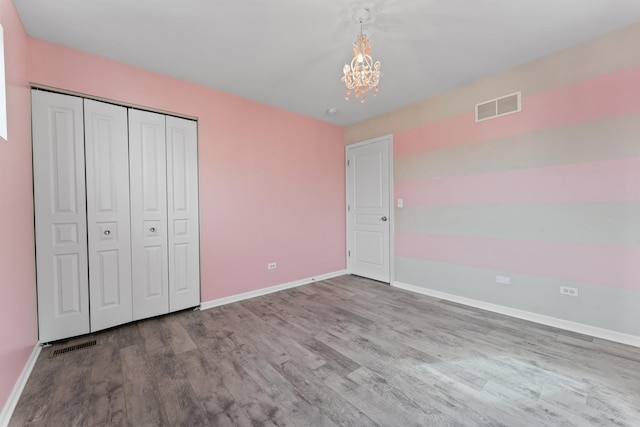 unfurnished bedroom with light wood-style floors, visible vents, and baseboards