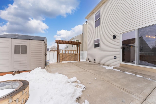 exterior space featuring an outbuilding, fence, a fire pit, and a storage unit