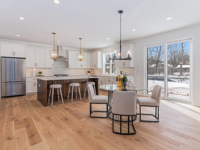 dining area featuring sink, an inviting chandelier, and light hardwood / wood-style flooring