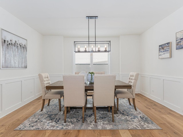 dining space with hardwood / wood-style floors and a chandelier