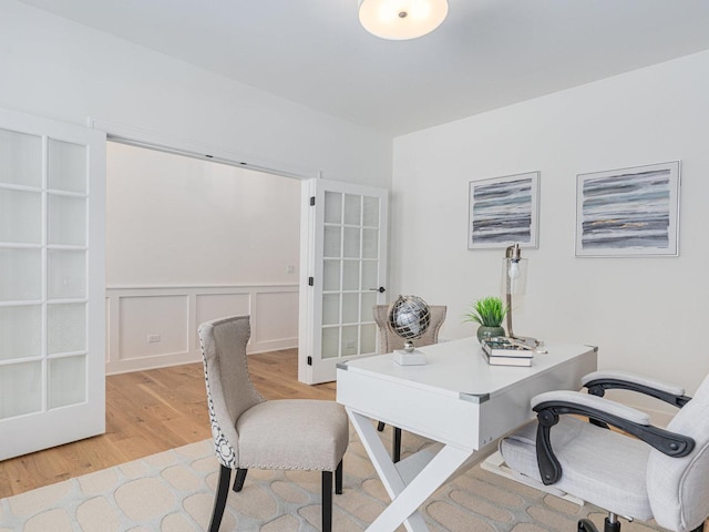 home office with french doors and light hardwood / wood-style floors