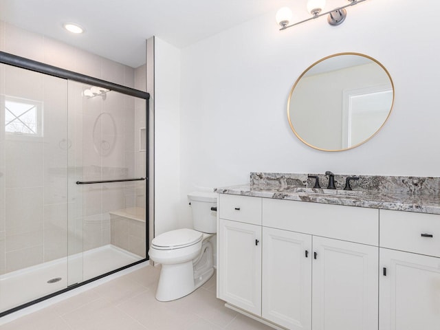 bathroom with tile patterned flooring, toilet, vanity, and walk in shower