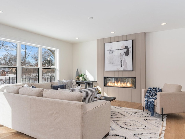 living room featuring light hardwood / wood-style floors and a large fireplace