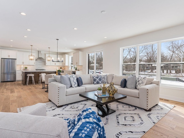 living room featuring a notable chandelier and light hardwood / wood-style flooring