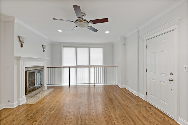 unfurnished living room with light hardwood / wood-style floors, ceiling fan, and ornamental molding