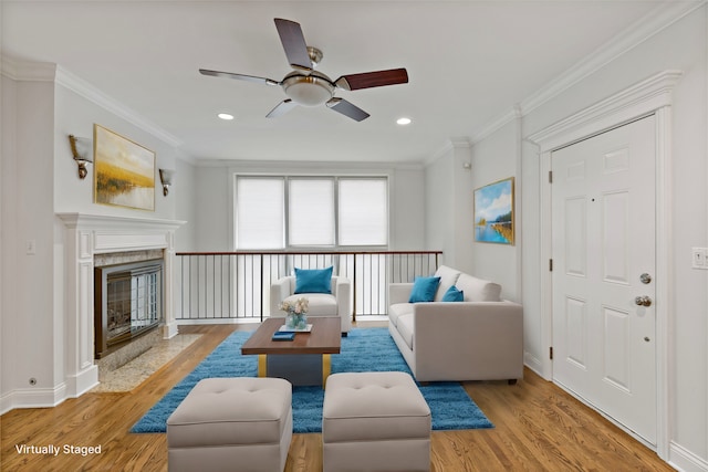 living room with ceiling fan, ornamental molding, and light hardwood / wood-style floors