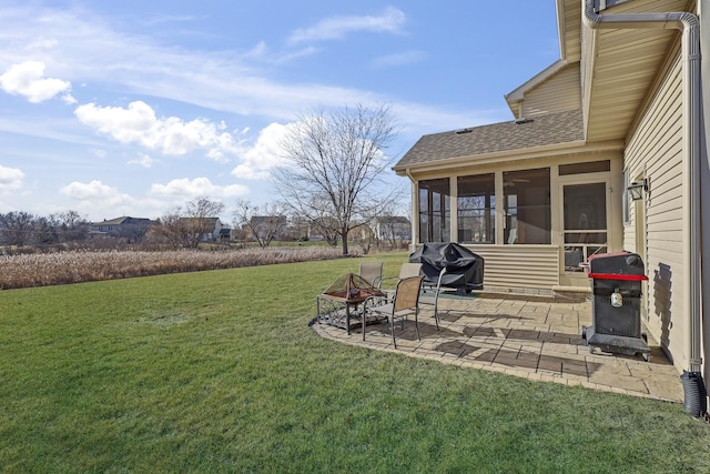 view of yard with a sunroom, an outdoor fire pit, and a patio