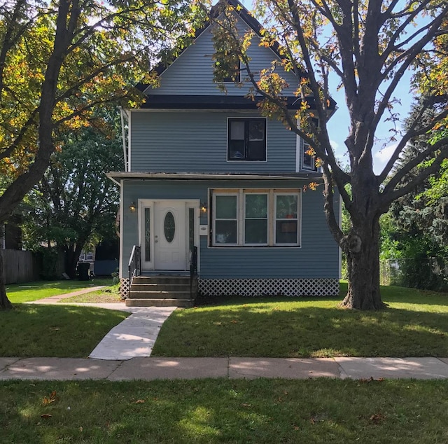 american foursquare style home with fence and a front lawn